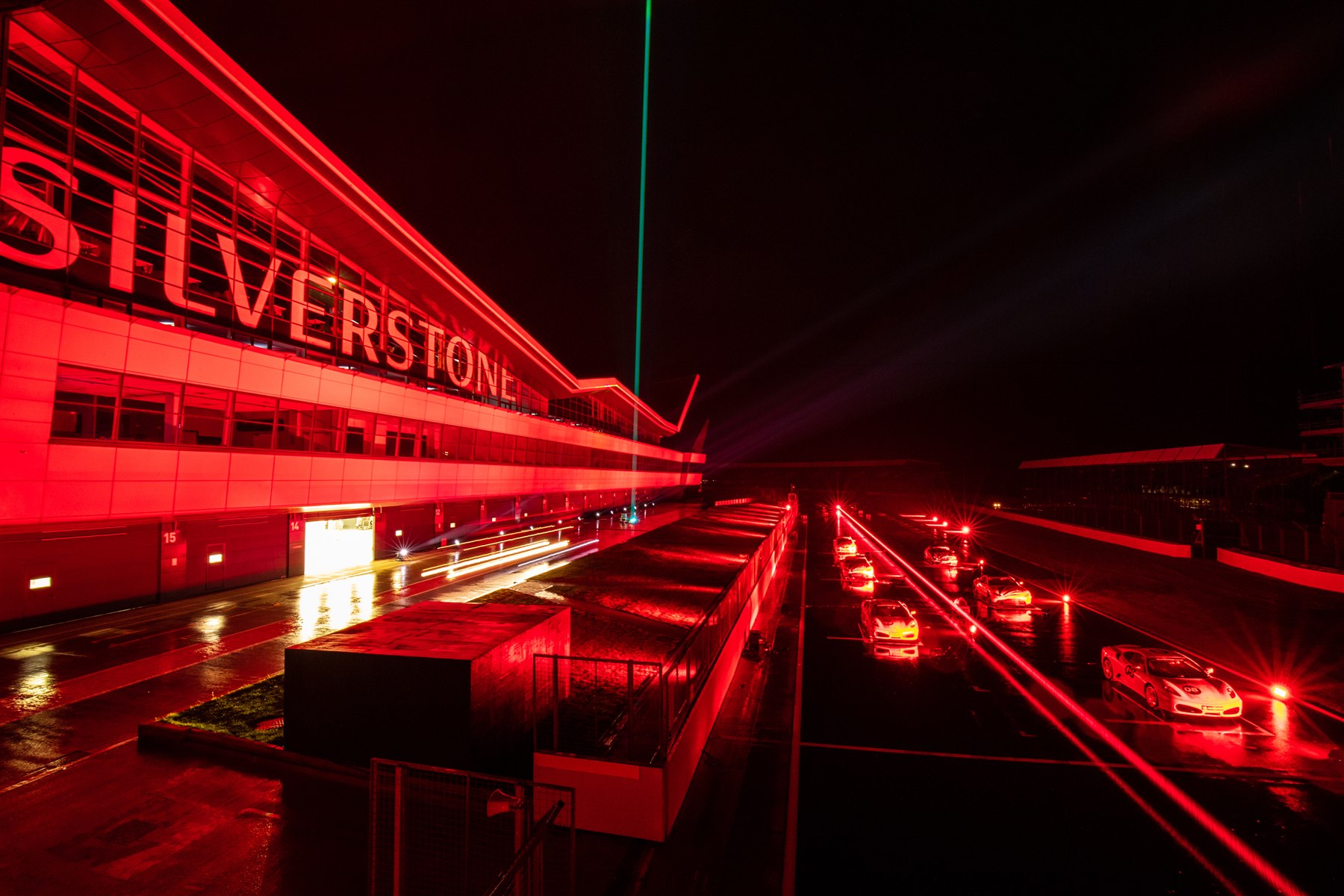 Green laser beam above the red-lit Silverstone building